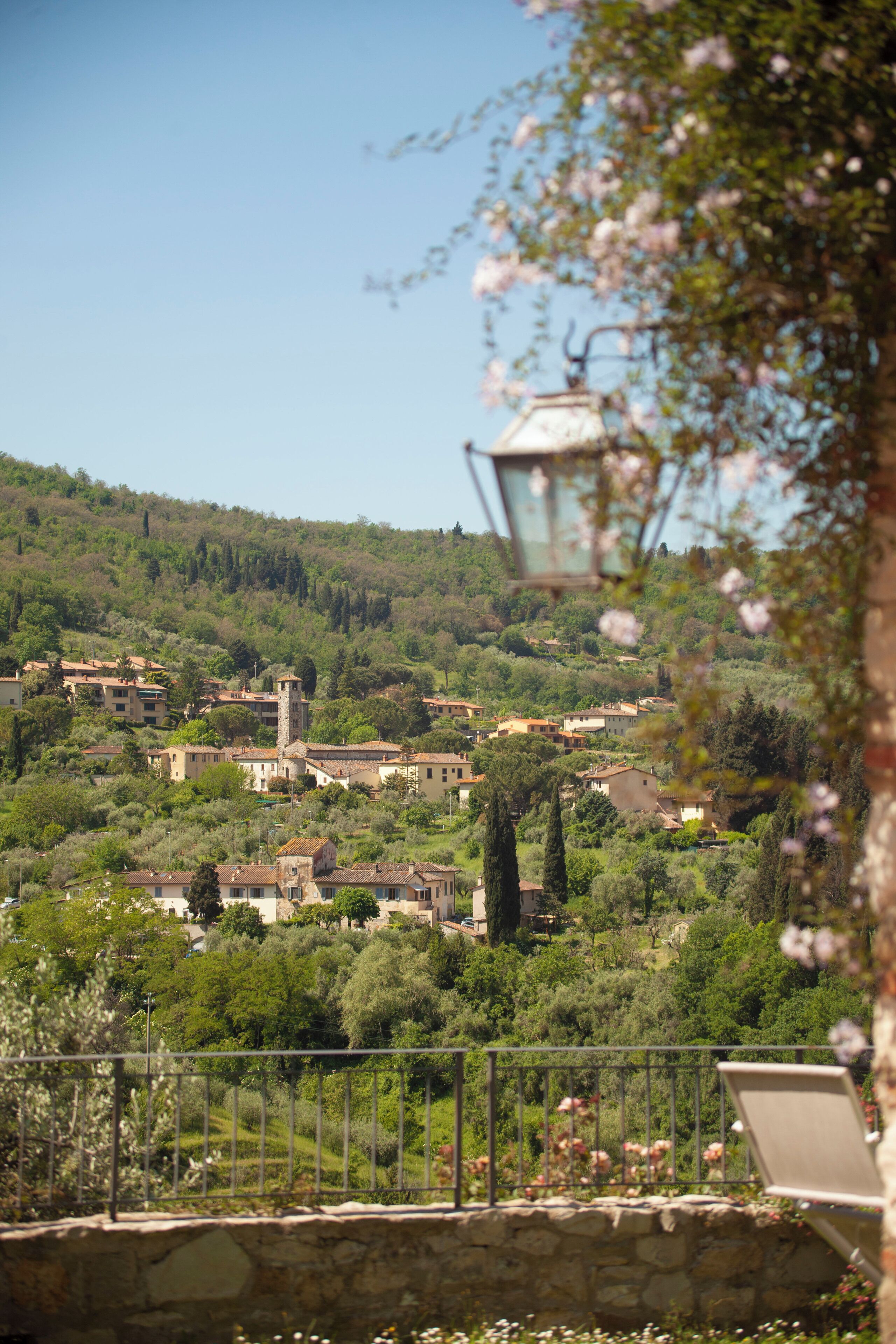 A hillside village with traditional architecture, stone walls, and a mix of residential and commercial buildings.