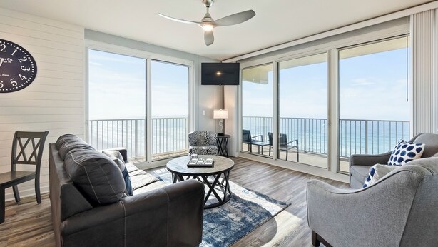 Un vaste balcon offrant une vue sur l’océan, aménagé avec un canapé, un fauteuil et une table ronde.