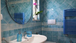 A bathroom with a large sink, a toilet, and a bidet. There is a mirror above the sink and a towel rack on the wall. - CASA RUBIS (Ruvo di Puglia)