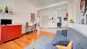 A modern living room with a red dresser, a grey sofa, and a television. - Casa Rachele Stresa Center (Stresa)