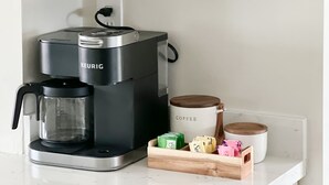 Cozinha com cafeteira Keurig, moedor de café e suporte para canecas.
