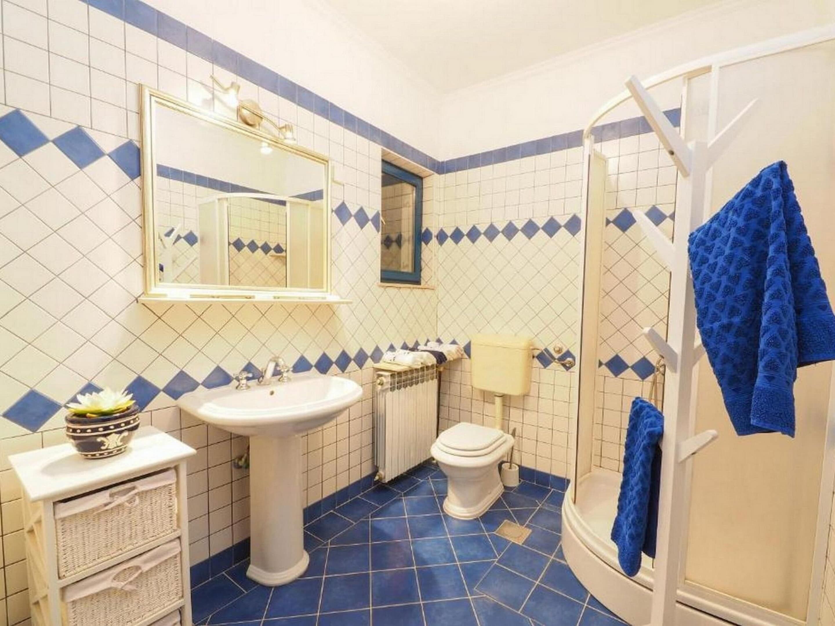 Un baño con lavamanos, inodoro y ducha.