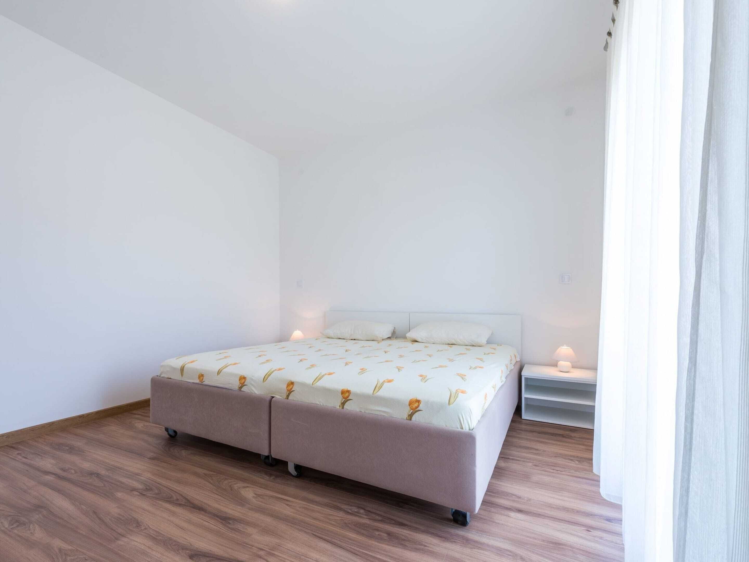 Une chambre à coucher avec un lit, des tables de chevet et une fenêtre avec des rideaux.