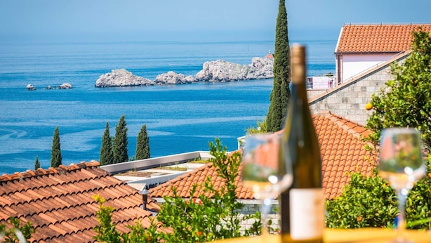 A coastal view with a table set for dining, overlooking the sea and rocky outcrops. - Apartments Lucija - Two Bedroom Apartment With Balcony and Sea View (Dubrovnik)