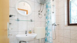 A bathroom with a toilet, sink, and shower. - Apartments Neva- One Bedroom Apartment (Selca)