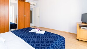 A bedroom with a bed, wardrobe, and a TV stand. - Apartments Bonavista - Premium Two Bedroom Apartment With Balcony and Sea View (Dubrovnik)
