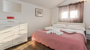 A bedroom with a bed, white dresser, and a window with sheer curtains. - Apartments Roda - Comfort One Bedroom Apartment With Terrace - (Supetar)