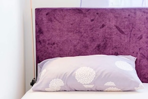 A bed with a purple headboard and a pillow with a white floral pattern. - Apartment Karlo - Two Bedroom Apartment With Balcony (Kastela)