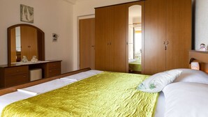 A bedroom with a bed, a wooden wardrobe, a mirror, and a dresser. - Apartments Belenum - Comfort Double Room With Balcony and Sea View (Zupa dubrovacka)