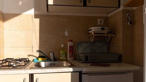 A compact kitchen with a gas stove, sink, and a small refrigerator. - Apartments Belenum - Comfort Double Room With Balcony and Sea View (Zupa dubrovacka)