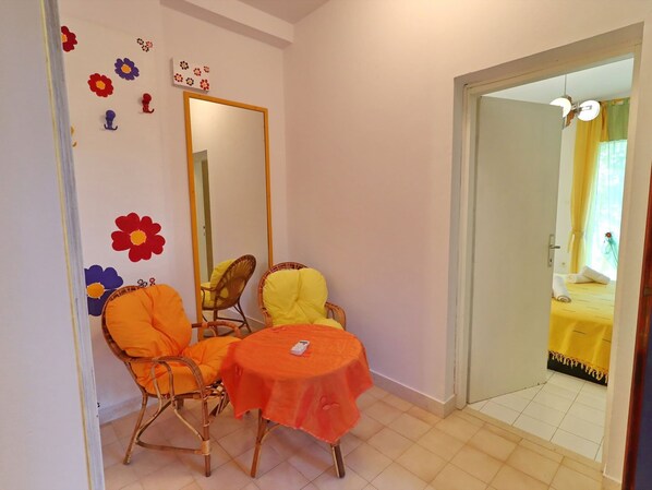 A small room with a dining table and two chairs, a mirror, and a door leading to another room. - Apartments More & Ja - One Bedroom Apartment With Terrace and Sea View (Ston)