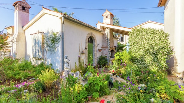 Un bâtiment traditionnel avec une façade en pierre, une porte verte et un petit clocher.