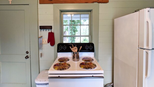 Una cocina con estufa, horno y ventana.
