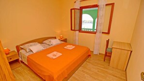 A bedroom with a single bed, a nightstand, a chair, and a window with curtains. - Apartments Bacic - Three Bedroom Apartment With Terrace and Sea View (Blato)