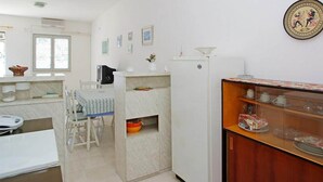 Cocina compacta con una mesa de comedor, un refrigerador y un mostrador tipo buffet.
