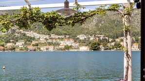 A coastal town with houses on a hillside, a body of water, and a lamp post. - Apartments Lion - Sea House 1 (Dubrovnik)