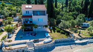 A two-story building with a swimming pool, a covered outdoor seating area, and a beachside location. - Apartments Kola's Mill - Comfort One Bedroom Apartment With Terrace and Sea View (Dubrovacko Primorje)