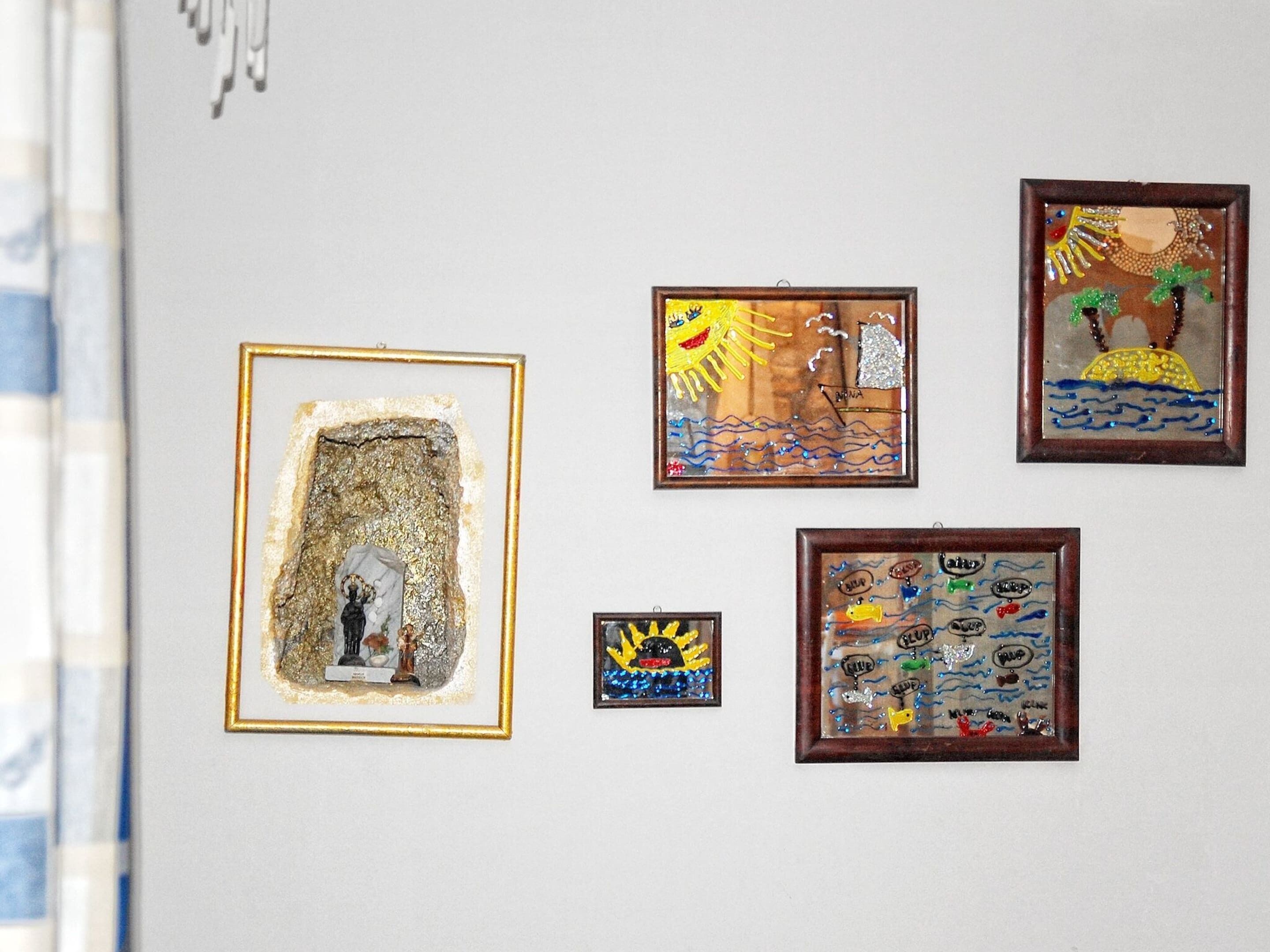 Four framed artworks on a wall.