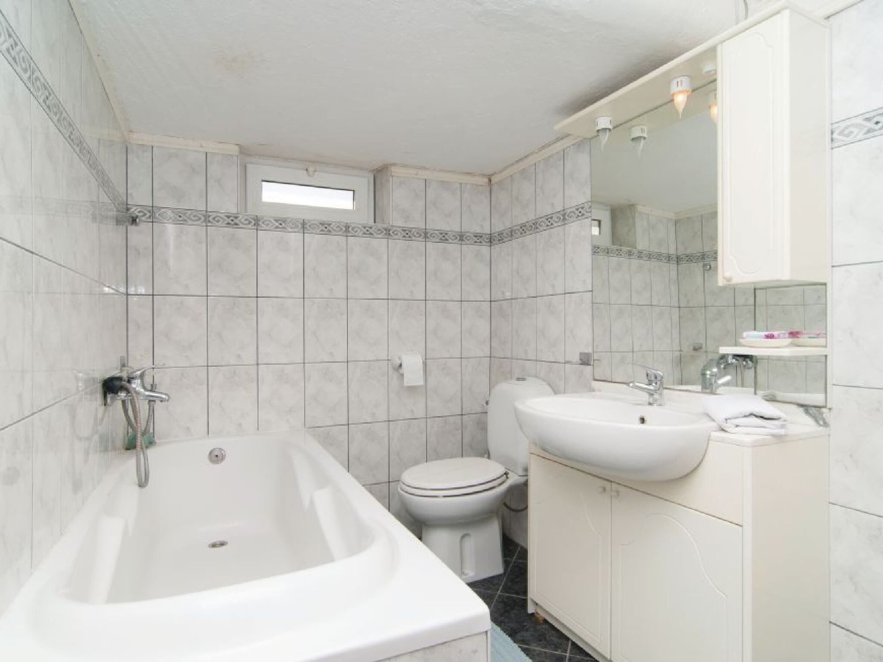 A bathroom with a bathtub, toilet, and sink.