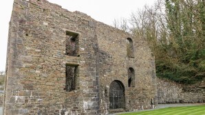 A historic stone building with arched windows and a gated entrance. - Seacroft (Narberth)