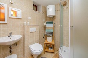 A bathroom with a sink, toilet, and a shower area. - Apartment Sympa - Studio Apartment A2 (Dubrovnik)