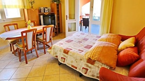 A bedroom with a bed, a dining table, chairs, a TV, and a door leading to a balcony. - Apartments Sea Line - Two Bedroom Apartment With Terrace and Sea View (Blato)