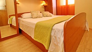 A bedroom with a wooden bed frame, a nightstand, a mirror, and a wardrobe with built-in shelves. - Apartments Sea Line - Two Bedroom Apartment With Terrace and Sea View (Blato)
