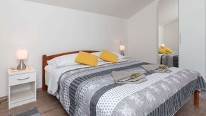 A bedroom with a bed, bedside tables, a mirror, and a nightstand.