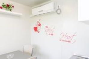 A room with a white wall, a small shelf with flowers, and a wall decal that says "Love at first sight." - Apartments Dalamar - Mobile Home With Patio (Mljet)