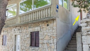 A stone building with a balcony, a staircase, and a door. - Seafront Apartments Olivera-standard One Bedroom Apartment With Balcony and Sea View (Blato)