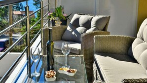 A balcony with wicker furniture, a glass table, and a view of the sea. - Fancy Apartments Dream - Modern One Bedroom Apartment With Balcony and Sea View (Smokvica)