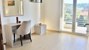 A modern room with a desk, chair, and a large window with a view of a balcony and buildings. - Fancy Apartments Dream - Modern One Bedroom Apartment With Balcony and Sea View (Smokvica)