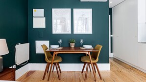 Un comedor con una mesa de madera, dos sillas y una planta en maceta.