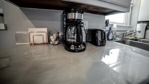 A kitchen with a coffee maker, a jar, and a toaster on the counter.