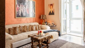 Un salon avec un canapé, une table basse et un tableau accroché au mur.