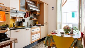 Une cuisine compacte avec des meubles en bois, une cuisinière encastrée et un coin repas comprenant une table et des chaises.