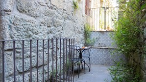 A narrow outdoor seating area with a stone wall, metal railing, and tiled floor. - Oporto Home Wine Cellars - Estúdio c/ Terraço 1ºT (Vila Nova de Gaia)