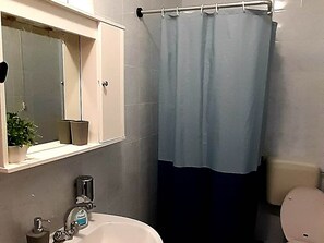 A bathroom with a white sink, a mirror above it, a toilet, and a shower curtain. - Apartments Cumbelic - One Bedroom Apartment With Balcony and Sea View A1 (Mljet)