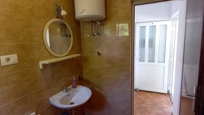 A bathroom with a sink, mirror, toilet, and a white water heater on the wall. - Apartments Vinko Mljet- One-bedroom Apartment With Terrace (Mljet)