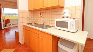 A compact kitchen with wooden cabinets, a microwave, and a sink. - Apartments Marko Peljesac - Standard One Bedroom Apartment With Balcony (Orebic)