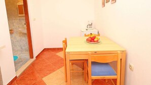 A small dining area with a table, chairs, a coffee maker, and a bowl of fruit. - Apartments Marko Peljesac - Standard One Bedroom Apartment With Balcony (Orebic)