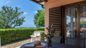 A patio with a table, a book, a hat, and a vase with plants. - Stylish Villa in Buje With Outdoor Kitchen (Buje)