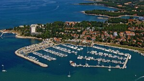 An aerial view of a marina with numerous boats docked, surrounded by residential buildings and greenery. - Stylish Villa in Buje With Outdoor Kitchen (Buje)