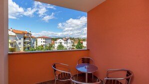 A balcony with a table and chairs, a view of residential buildings, and a clear sky. - Apartment in Medulin With Balconies (Medulin)