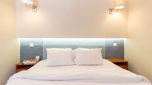 A hotel room with a bed, two bedside tables, and wall-mounted lights. - Oporto Home Wine Cellars - Estúdio com Varanda 3T (Vila Nova de Gaia)