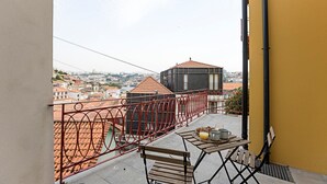 A balcony with a table, chairs, and a view of the cityscape. - Superb Flat w/ Balcony and AC by LovelyStay (Porto)