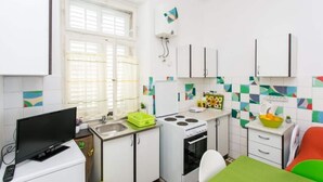 Una cocina compacta con estufa, lavamanos y un pequeño comedor.