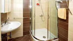 Une salle de bain moderne avec une douche à parois de verre, un lavabo et un porte-serviettes.