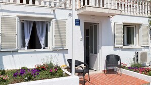 A two-story building with a balcony, white exterior walls, and a sign indicating it is a "PARTMAN" establishment. - Apartment Semi - One Bedroom Apartment With Terrace and Sea View (Dubrovnik)
