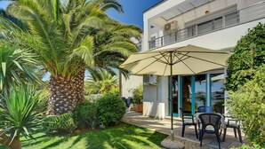 Un edificio moderno con un patio cubierto y mobiliario exterior.